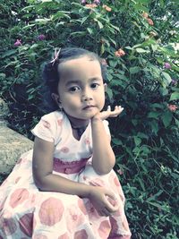 Portrait of cute girl sitting outdoors