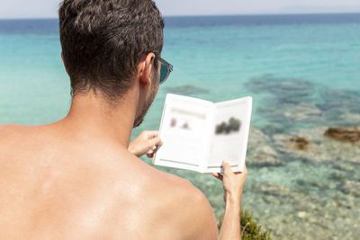 Young man is reading a book next to the vacation concept.