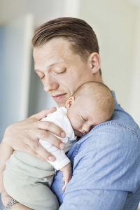 Father carrying baby girl at home