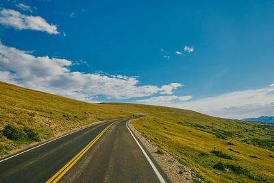 Road passing through landscape against sky