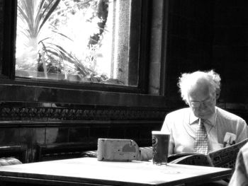 Man looking at camera while sitting on table