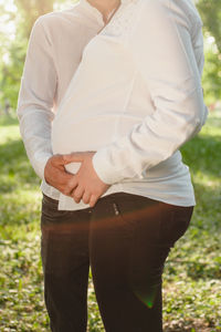 Midsection of young couple standing at park