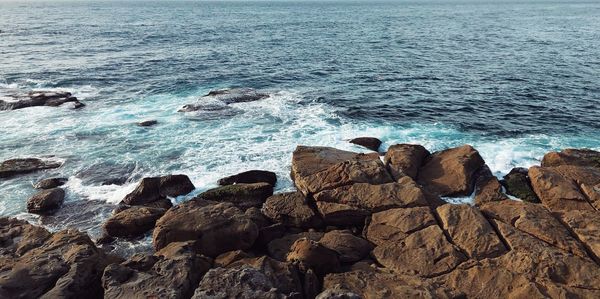 High angle view of rocks on sea shore