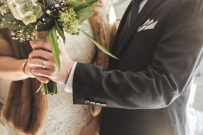 Midsection of man holding flower bouquet