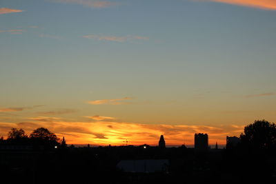 Silhouette of city against sky during sunset