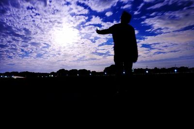 Silhouette of woman standing against sky