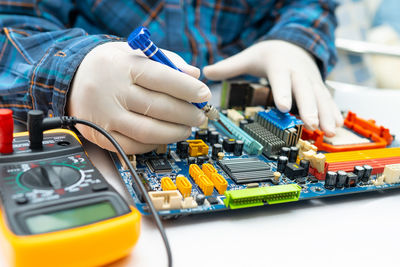 Close-up of hand holding smart phone on table