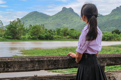 Side view of woman wearing uniform looking at mountains
