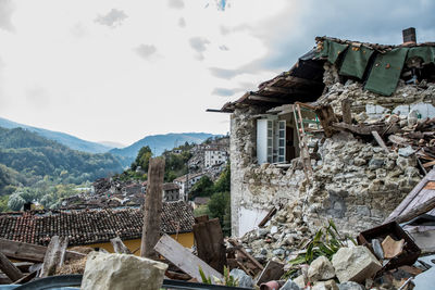 Old building by mountains against sky