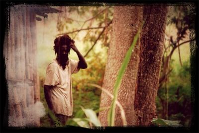 Woman standing on tree trunk