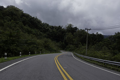 Road amidst trees against sky