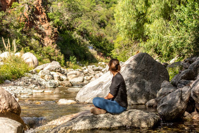 Full length of man sitting on rock