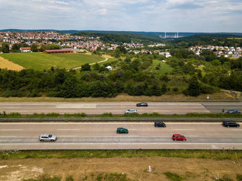 High angle view of cars on road amidst field against sky
