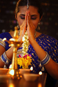 Beautiful indian woman in sari praying during diwali