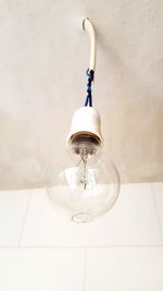 Low angle view of light bulb hanging on ceiling