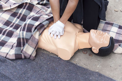 Midsection of paramedic performing cpr on mannequin