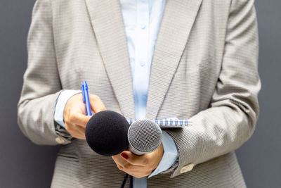 Midsection of a woman holding microphone