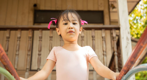 Cute girl standing against house