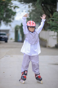 Portrait of boy standing on footpath