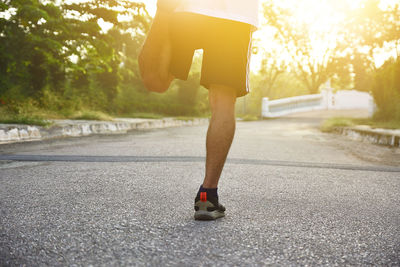 Low section of man running on road