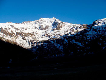 Scenic view of snowcapped mountains against clear blue sky