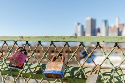 Close-up of padlocks on chainlink fence against clear sky