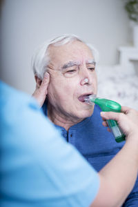 Gereatric nurse helping patient with a nebulizer