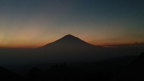 Scenic view of silhouette mountains against sky during sunset