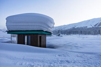 Built structure on snow covered mountain against sky