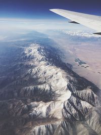 Cropped image of airplane flying over mountain range