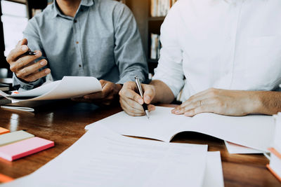 Midsection of business people working at desk in office