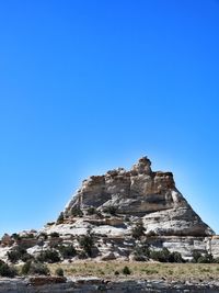 Low angle view of castle on mountain against clear blue sky