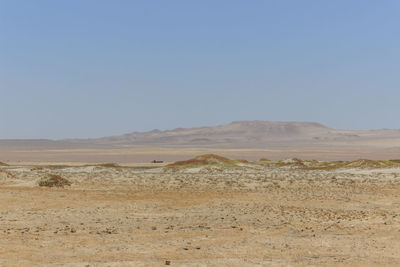 Scenic view of desert against clear blue sky