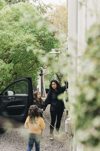 Woman standing on road against plants