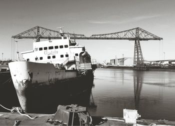 Cranes at commercial dock against sky