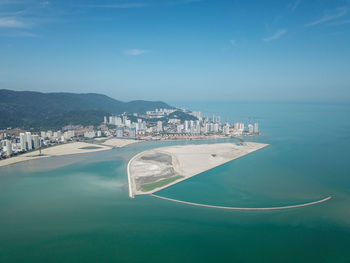 Aerial view of sea and city against sky