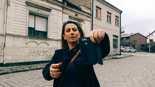 Woman using mobile phone in city