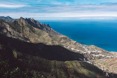 Scenic view of sea and mountains against sky