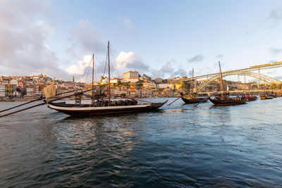 Sailboats moored at harbor