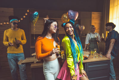 Portrait of smiling friends standing in city