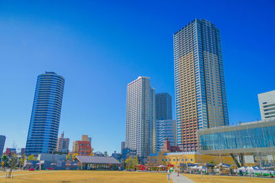 Modern buildings in city against blue sky