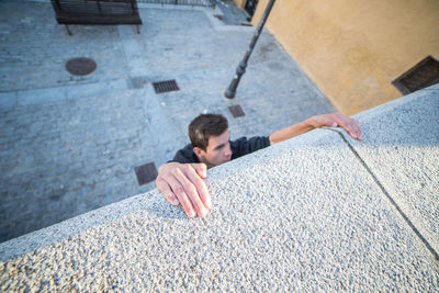 High angle view of man climbing concrete wall