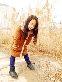 Portrait of girl wearing warm clothing against grass