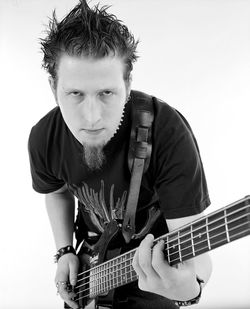 Portrait of man playing guitar against white background