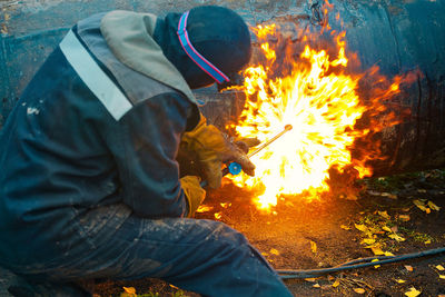 Side view of man working on fire