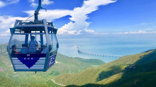 People in cable car against sky