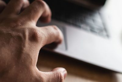 Close-up of hand using laptop