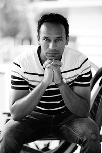 Portrait of man sitting on chair outdoors