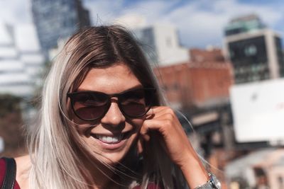 Portrait of smiling young woman wearing sunglasses