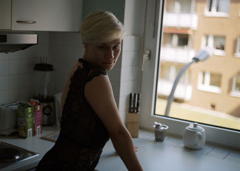 Side view of young woman standing at home